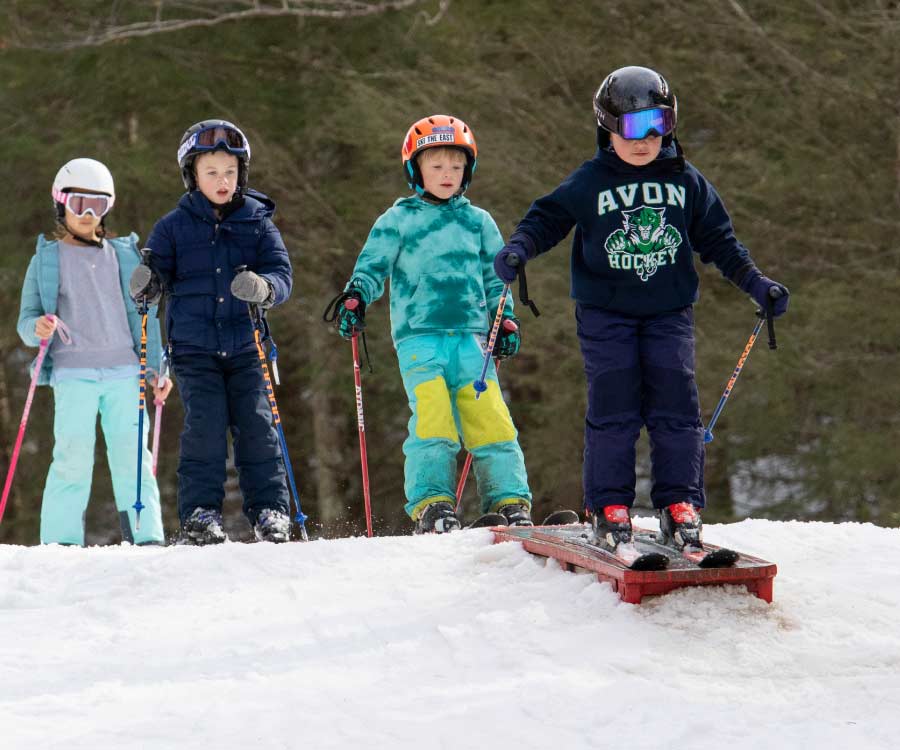 Skier on small box in Tom's Treat terrain park.