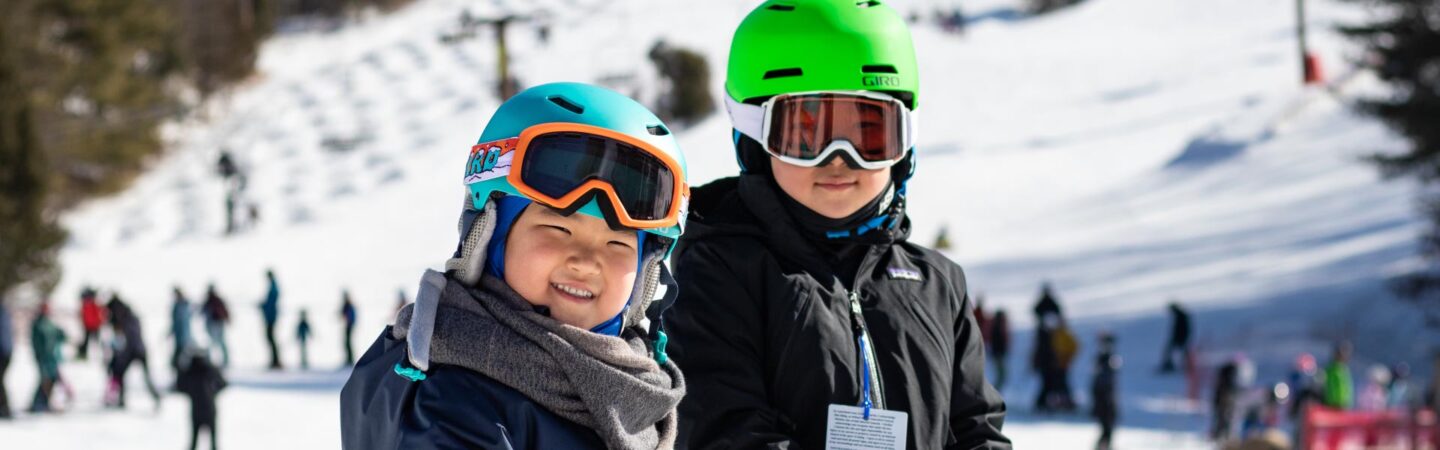Two children skiers at base of trail