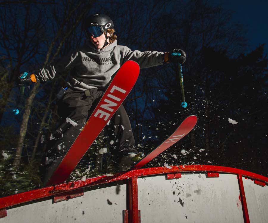 Skier on rainbow rail in Stinger terrain park.
